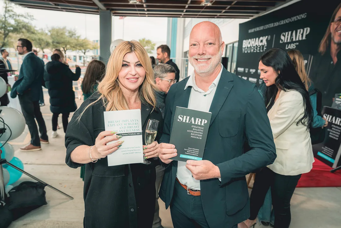 Guests holding books and the magazine at a grand opening